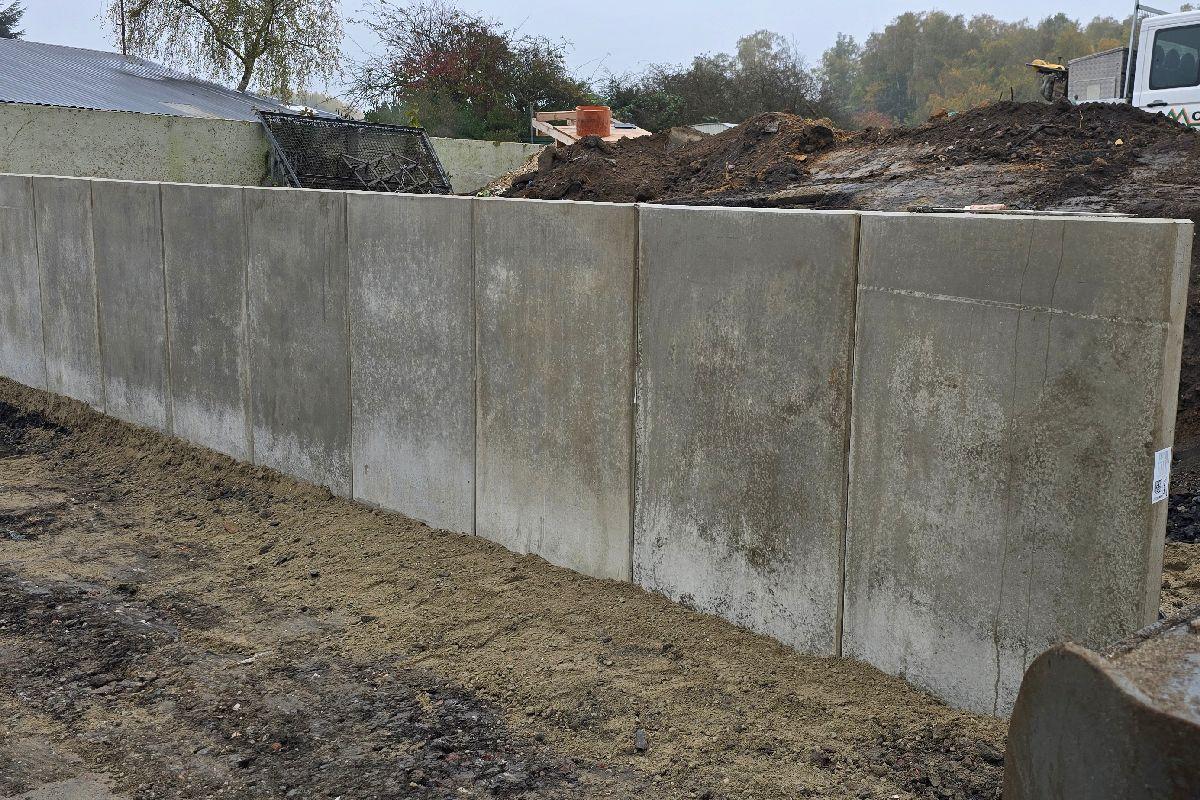 Hier ist die neue L-Steinwand zu sehen. Sie sichert die Böschung ab und sorgt dafür, dass unterschiedliche Geländesprünge abgefangen werden.